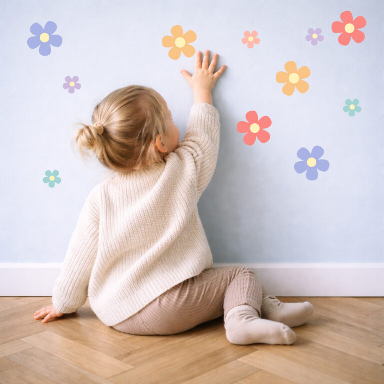 Daisy (multicoloured) wall stickers being stuck on the wall by a child