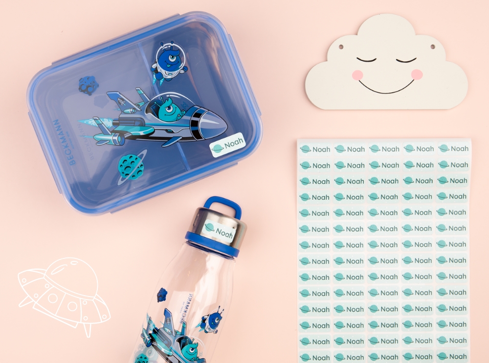 Blue lunchbox, drinking bottle, and name labels with a space-themed design.