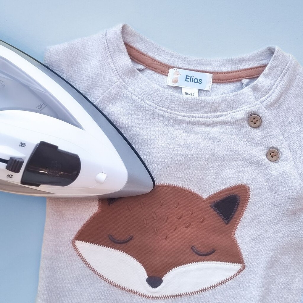 Applying an iron-on name label to a children's sweatshirt