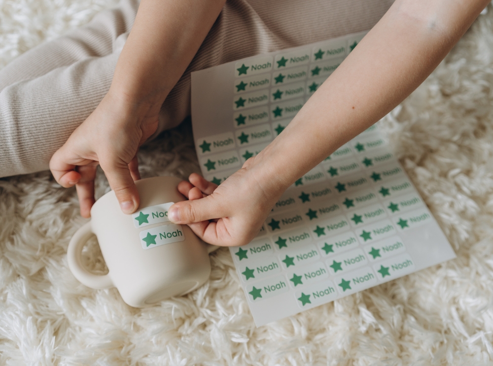Keeping kids safe every day: the benefits of name labels for kids 3 Applying a personalised name label to a kids' cup