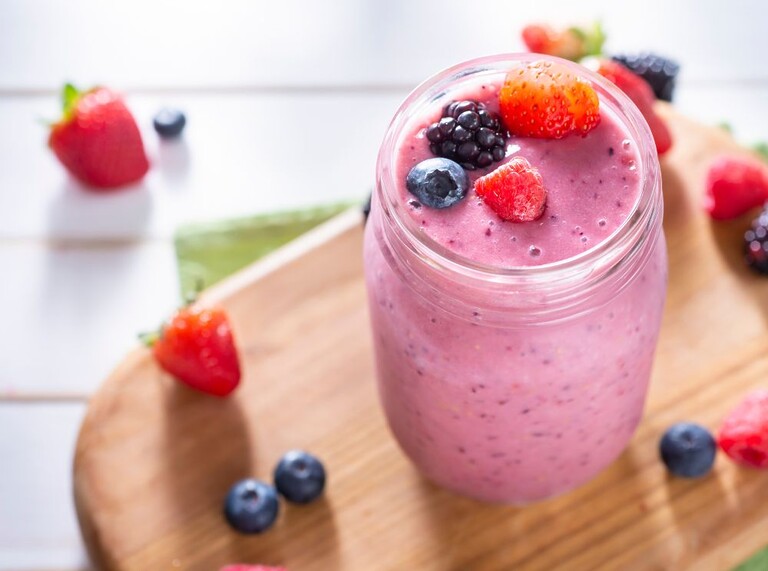 Close-up of a pink refreshing smoothie topped with fresh berries