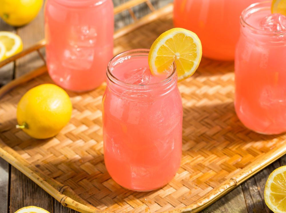 Child-friendly pink lemonade in a mason jar with ice and a lemon slice