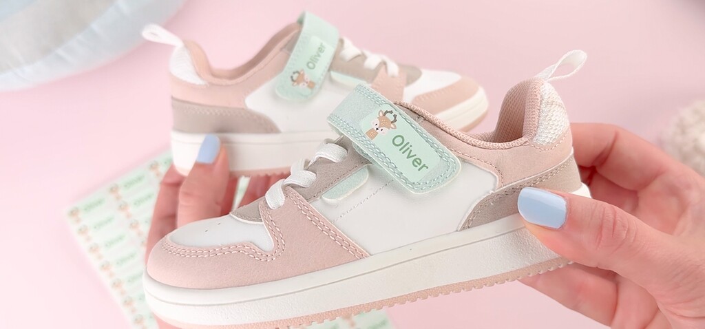 Close-up of a toddler shoe with a personalized name label on the strap
