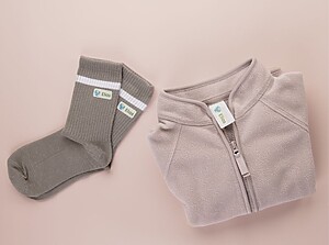 Folded jacket and socks labeled with personalized name labels