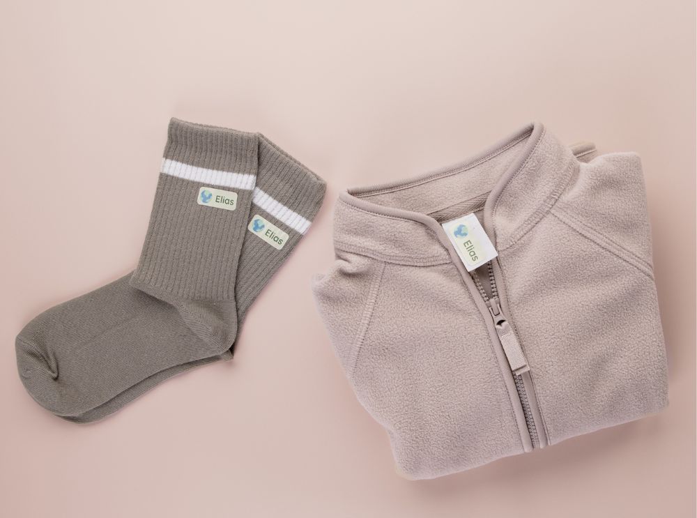 Folded jacket and socks labeled with personalised name labels