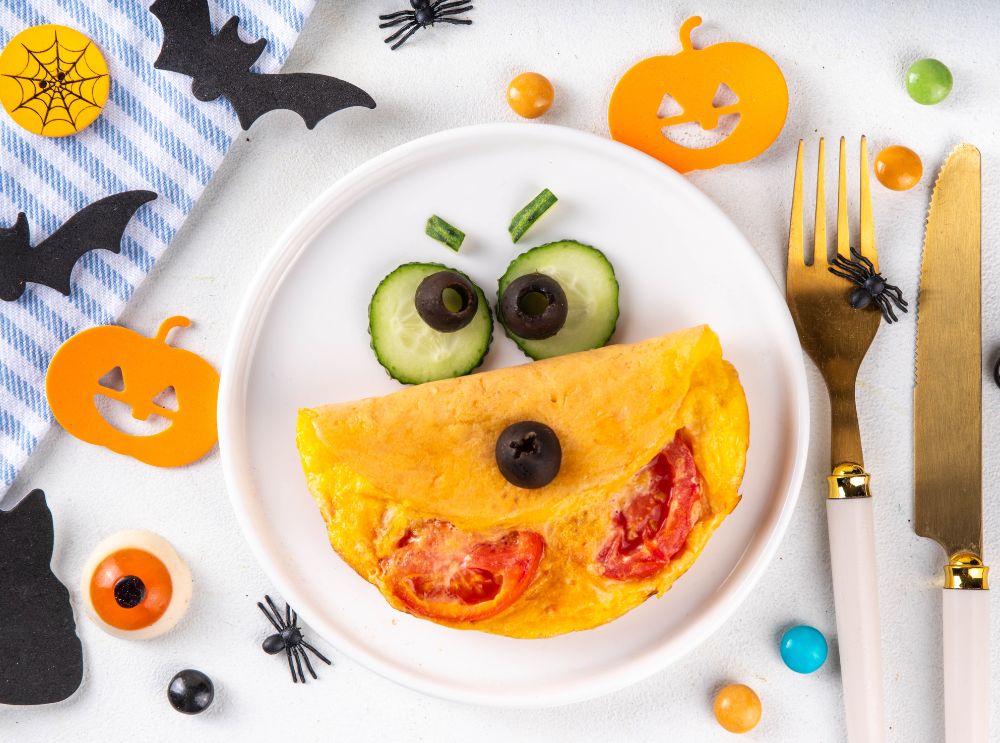 Halloween-inspired omelette decorated with cucumber and olives as a funny face