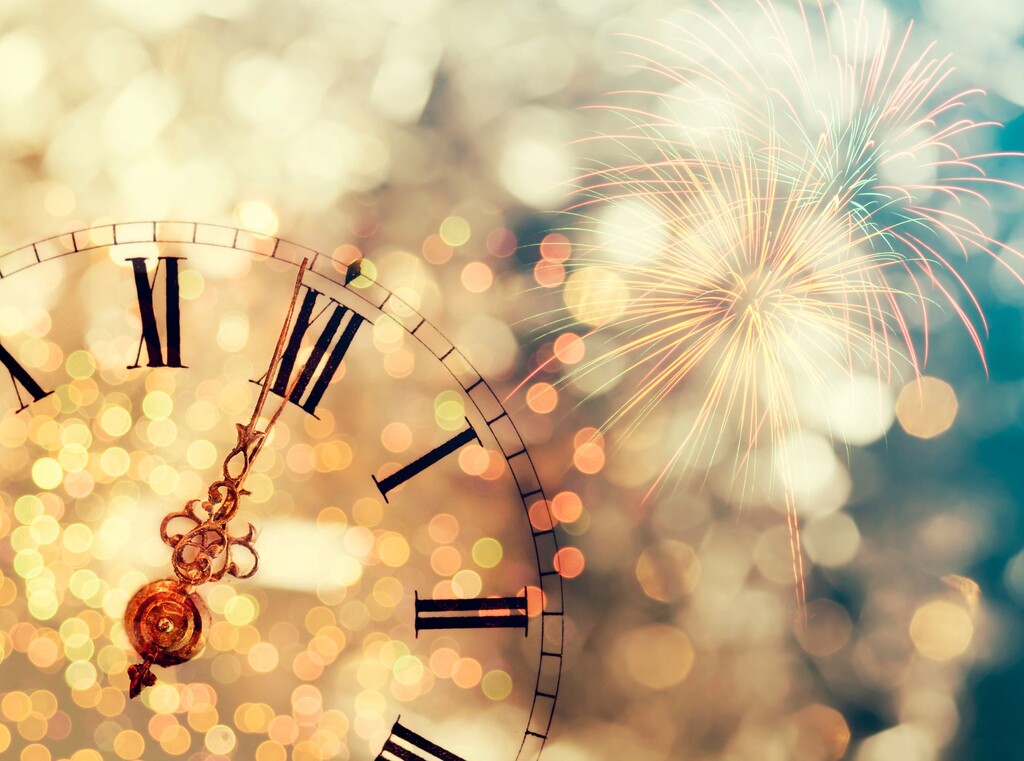 New year’s eve with kids: fun ideas for a night to remember 2 Clock near midnight with bright new year’s fireworks behind.