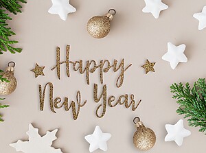 “Happy New Year” gold lettering surrounded by white stars and festive decorations