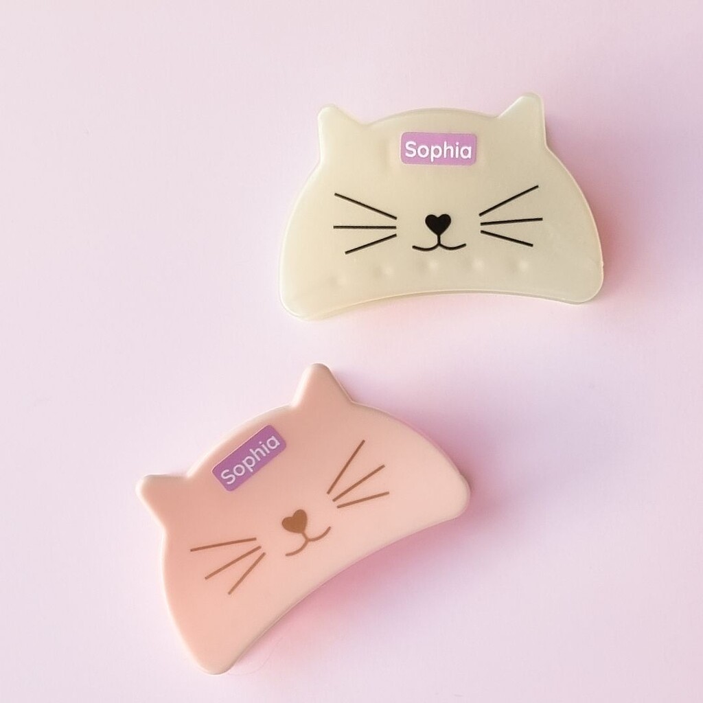 Personalised purple mini labels with the name sophia, applied to hair clips with cute cat faces