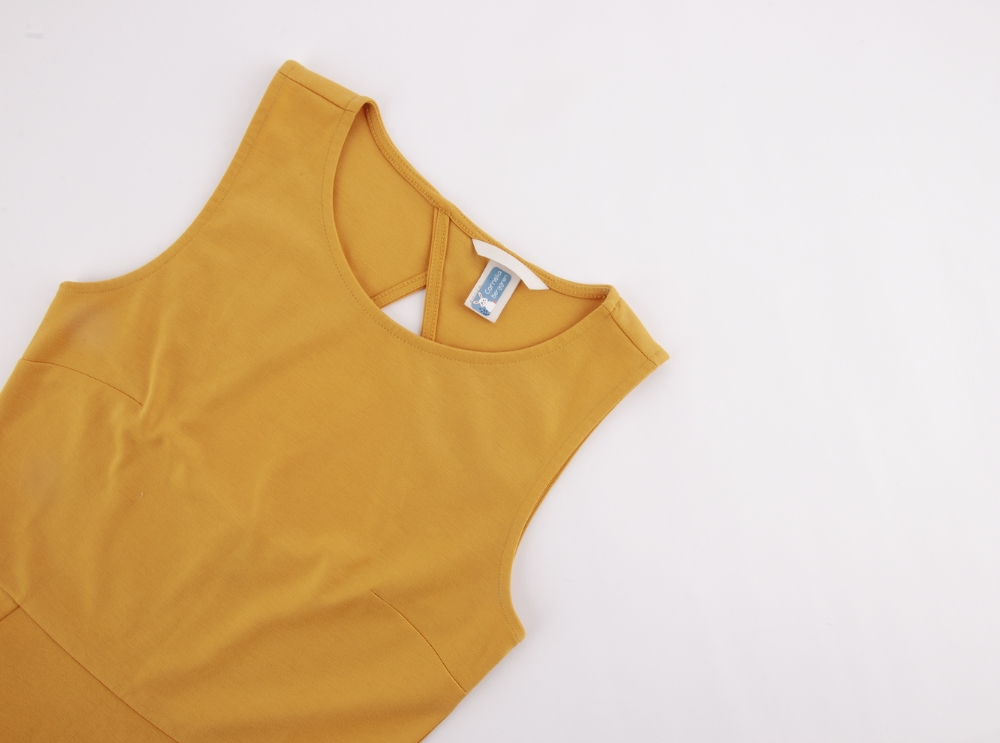 Yellow dress with a personalised name label applied to the care tag at the neckline.