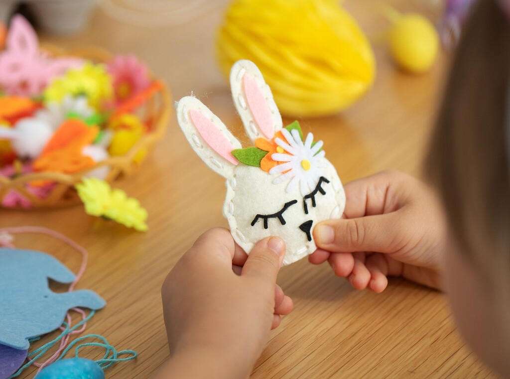 Child holding a handmade felt bunny decorated with flowers