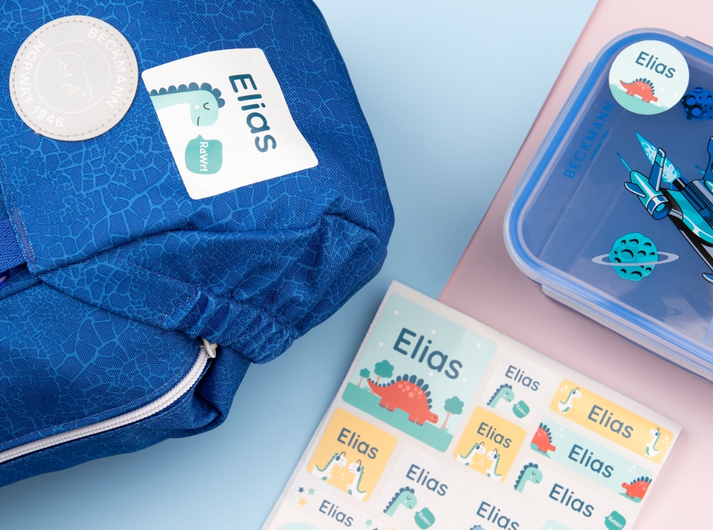 From preschool to reception: how early learning builds a strong foundation 3 Colourful namelabels with dinosaur designs on a backpack, lunchbox, and sticker sheet