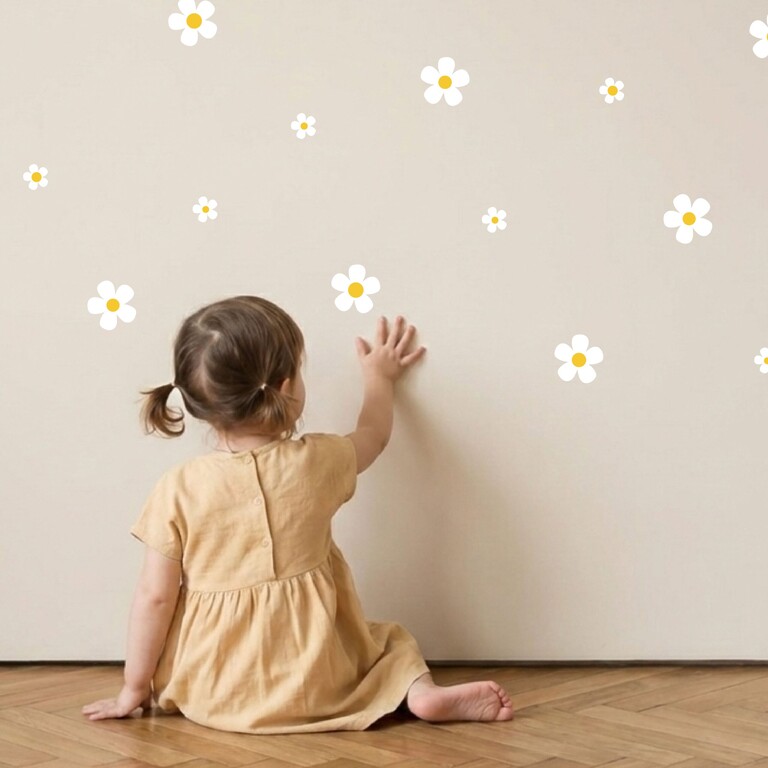 Daisy (white) wall stickers being stuck on the wall by a child