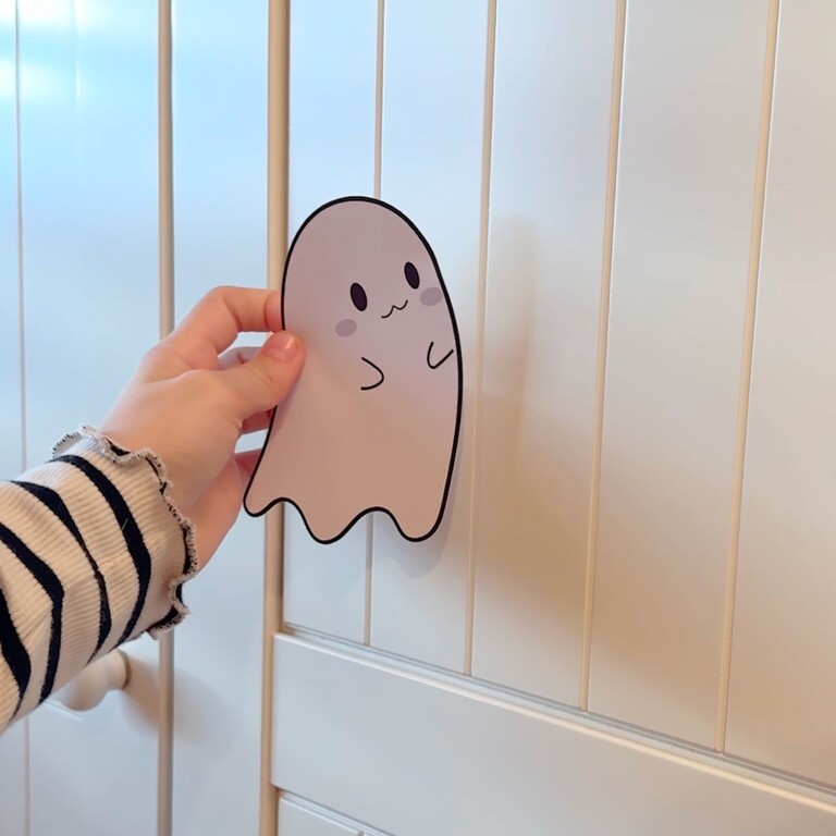 Child sticking a ghost wall sticker on a wardrobe