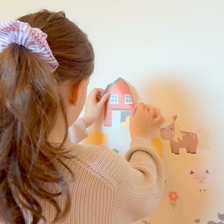 girl sticking wall stickers on a wall